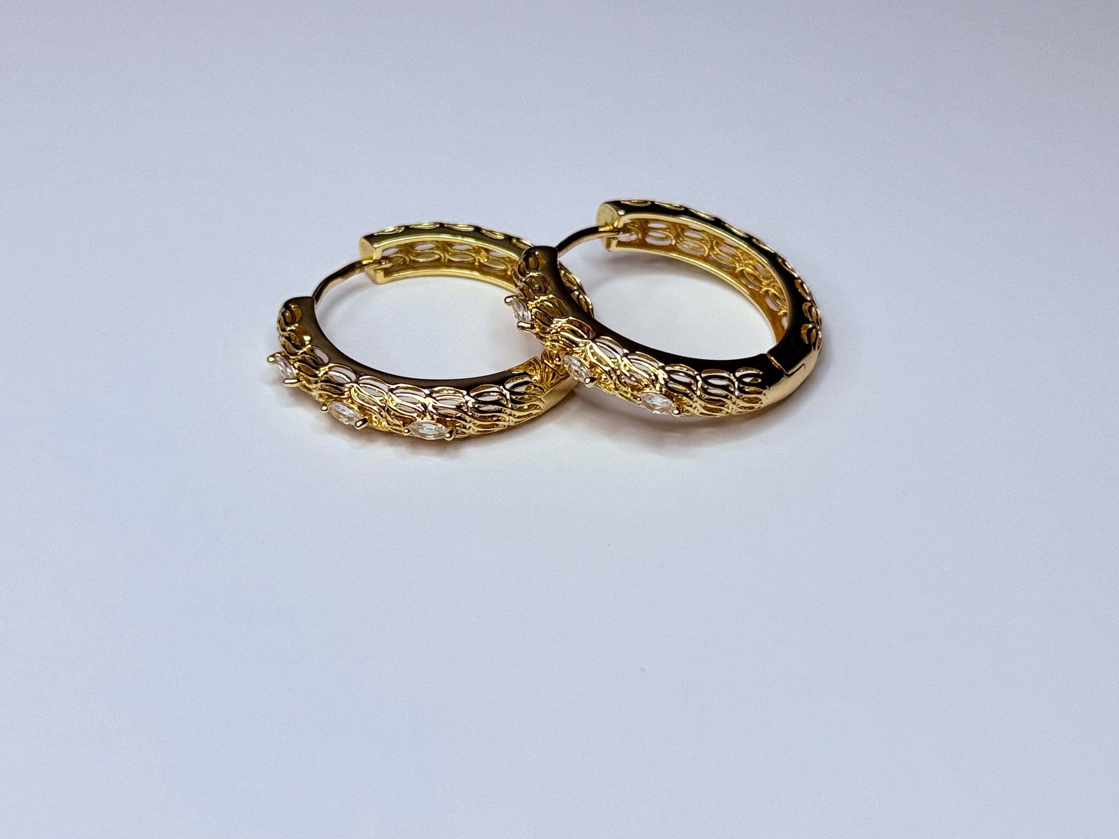 Gold earring with cubic zirconia.
