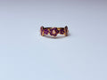 Rose gold floral ring with small violet pearls.