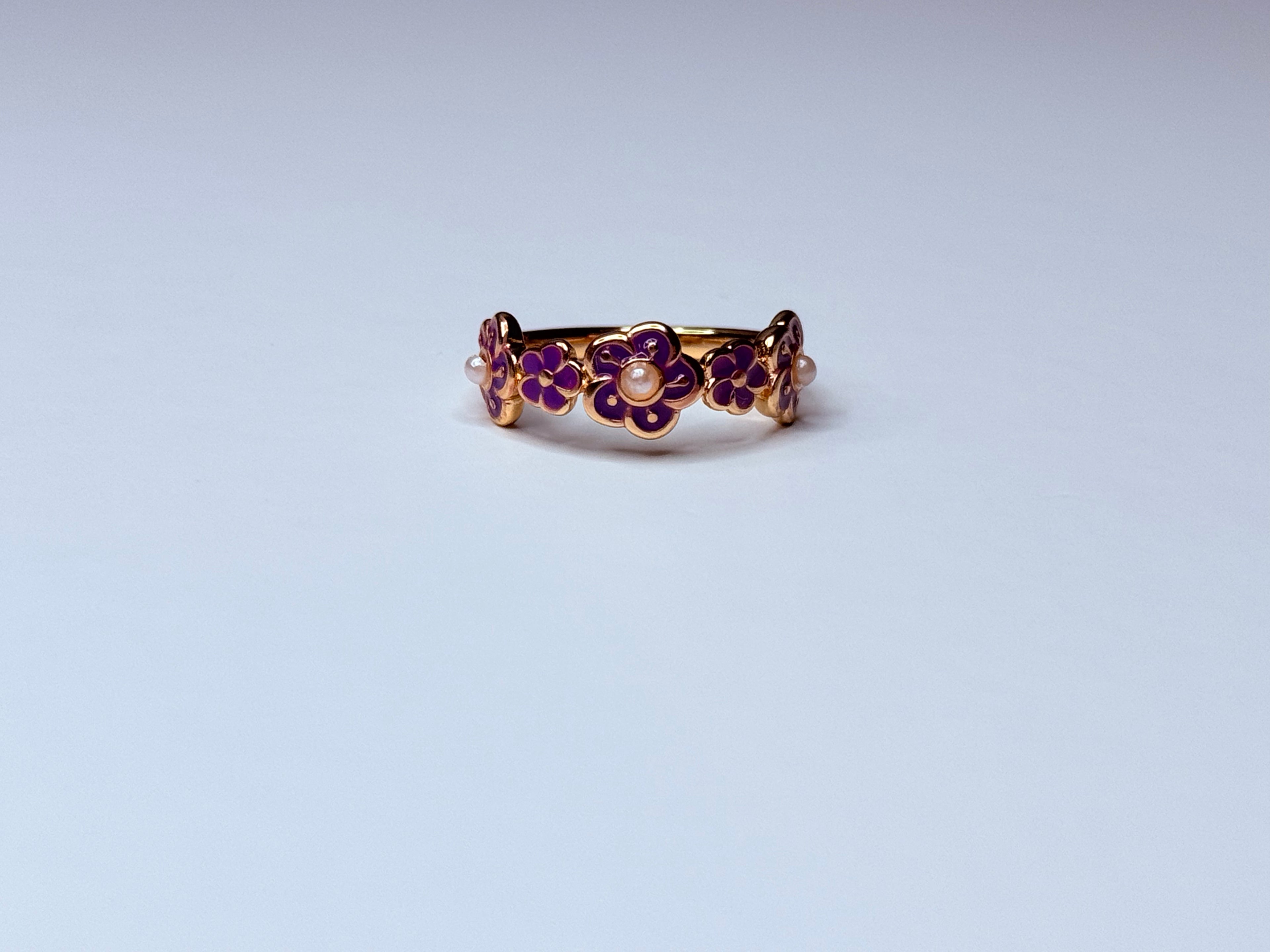 Rose gold floral ring with small violet pearls.